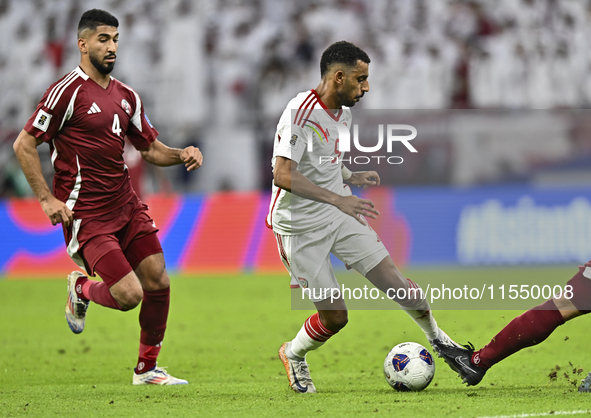 Mohammed Waad of Qatar battles for the ball with Harib Abdalla of the United Arab Emirates during the qualification 3rd round for the FIFA W...