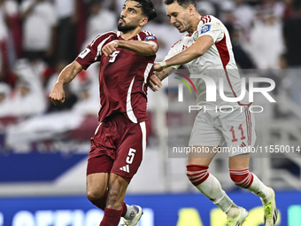 Tarek Salman of Qatar battles for the ball with Caio Correa of the United Arab Emirates during the qualification 3rd round for the FIFA Worl...