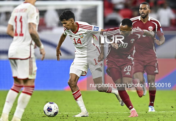 Ahmed Fathy of Qatar battles for the ball with Abdulla Almenhali of the United Arab Emirates during the qualification 3rd round for the FIFA...