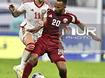 Ahmed Fathy (R) of Qatar battles for the ball with Caio Correa (L) of the United Arab Emirates during the qualification 3rd round for the FI...