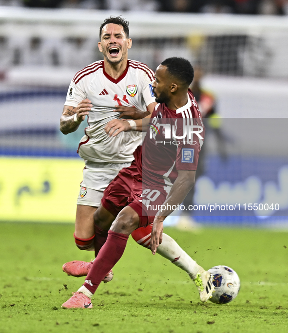 Ahmed Fathy (R) of Qatar battles for the ball with Caio Correa (L) of the United Arab Emirates during the qualification 3rd round for the FI...