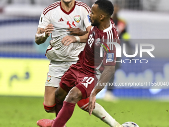 Ahmed Fathy (R) of Qatar battles for the ball with Caio Correa (L) of the United Arab Emirates during the qualification 3rd round for the FI...