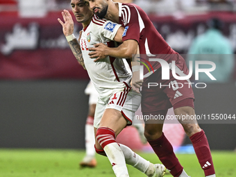 Tarek Salman (R) of Qatar battles for the ball with Caio Correa (L) of the United Arab Emirates during the qualification 3rd round for the F...