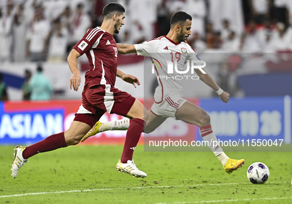 Karim Boudiaf (R) of Qatar battles for the ball with Khaled Aldhanhani (L) of the United Arab Emirates during the qualification 3rd round fo...