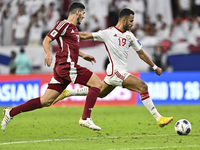 Karim Boudiaf (R) of Qatar battles for the ball with Khaled Aldhanhani (L) of the United Arab Emirates during the qualification 3rd round fo...