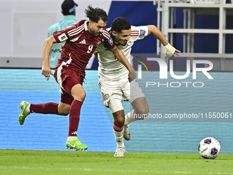 Abdelrahman Fahmi (L) of Qatar battles for the ball with Ali Saleh Amro (R) of the United Arab Emirates during the qualification 3rd round f...