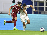 Abdelrahman Fahmi (L) of Qatar battles for the ball with Ali Saleh Amro (R) of the United Arab Emirates during the qualification 3rd round f...