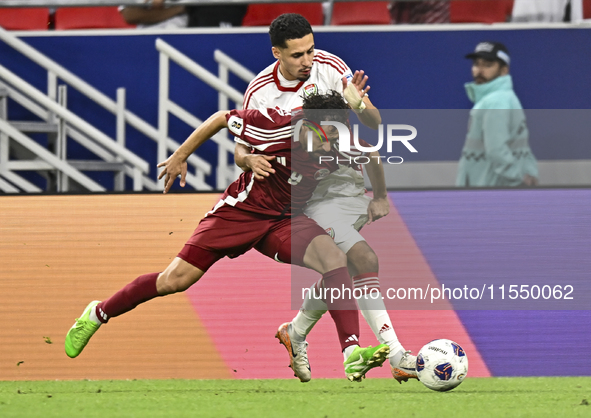 Abdelrahman Fahmi (L) of Qatar battles for the ball with Ali Saleh Amro (R) of the United Arab Emirates during the qualification 3rd round f...