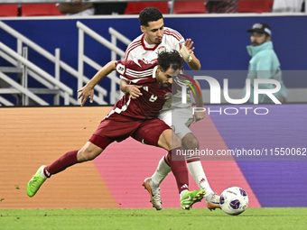 Abdelrahman Fahmi (L) of Qatar battles for the ball with Ali Saleh Amro (R) of the United Arab Emirates during the qualification 3rd round f...