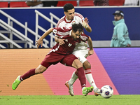 Abdelrahman Fahmi (L) of Qatar battles for the ball with Ali Saleh Amro (R) of the United Arab Emirates during the qualification 3rd round f...