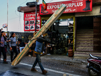 A laborer carries a heavy load of wood along the Mall Road in Mussoorie, Uttarakhand, India, on April 18, 2024. (