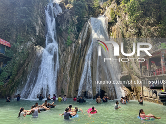 Indian tourists enjoy the cool water at Kempty Falls near the town of Mussoorie, Uttarakhand, India, on April 18, 2024. Kempty Falls is well...