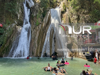 Indian tourists enjoy the cool water at Kempty Falls near the town of Mussoorie, Uttarakhand, India, on April 18, 2024. Kempty Falls is well...