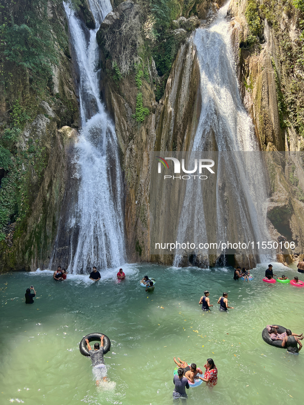 Indian tourists enjoy the cool water at Kempty Falls near the town of Mussoorie, Uttarakhand, India, on April 18, 2024. Kempty Falls is well...