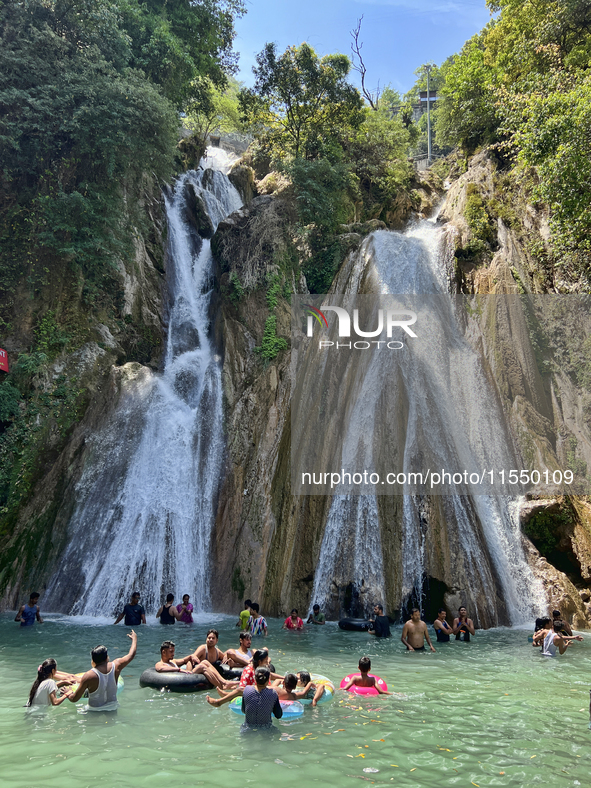 Indian tourists enjoy the cool water at Kempty Falls near the town of Mussoorie, Uttarakhand, India, on April 18, 2024. Kempty Falls is well...