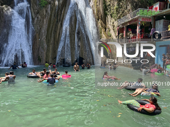 Indian tourists enjoy the cool water at Kempty Falls near the town of Mussoorie, Uttarakhand, India, on April 18, 2024. Kempty Falls is well...