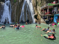 Indian tourists enjoy the cool water at Kempty Falls near the town of Mussoorie, Uttarakhand, India, on April 18, 2024. Kempty Falls is well...