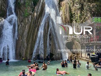 Indian tourists enjoy the cool water at Kempty Falls near the town of Mussoorie, Uttarakhand, India, on April 18, 2024. Kempty Falls is well...