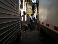 People commute by walking alongside roads filled with parked trucks as truckers demonstrate against the increase in diesel prices in Bogota,...