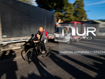 A couple commutes on a bike alongside several trucks parked in the streets as truckers demonstrate against the increase in diesel prices in...