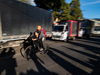 A couple commutes on a bike alongside several trucks parked in the streets as truckers demonstrate against the increase in diesel prices in...