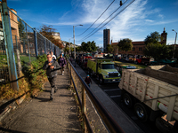 People commute by walking alongside roads filled with parked trucks as truckers demonstrate against the increase in diesel prices in Bogota,...