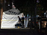 Crime scene investigators place evidence markers at the scene where 26-year-old male Mario Guerrero is shot in the head and pronounced dead...