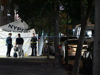 Crime scene investigators place evidence markers at the scene where 26-year-old male Mario Guerrero is shot in the head and pronounced dead...