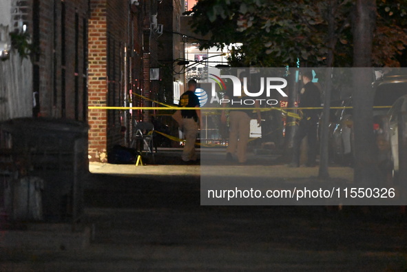 Crime scene investigators place evidence markers at the scene where 26-year-old male Mario Guerrero is shot in the head and pronounced dead...