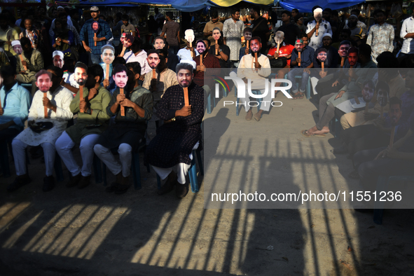 People hold placards with the faces of martyrs at the 'Shohidra Fire Ashche' event, held in memory of those killed in the anti-discriminatio...