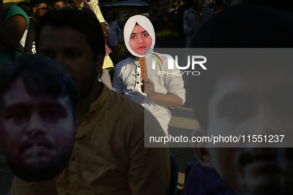 People hold placards with the faces of martyrs at the 'Shohidra Fire Ashche' event, held in memory of those killed in the anti-discriminatio...