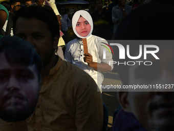 People hold placards with the faces of martyrs at the 'Shohidra Fire Ashche' event, held in memory of those killed in the anti-discriminatio...