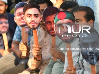 People hold placards with the faces of martyrs at the 'Shohidra Fire Ashche' event, held in memory of those killed in the anti-discriminatio...