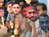 People hold placards with the faces of martyrs at the 'Shohidra Fire Ashche' event, held in memory of those killed in the anti-discriminatio...