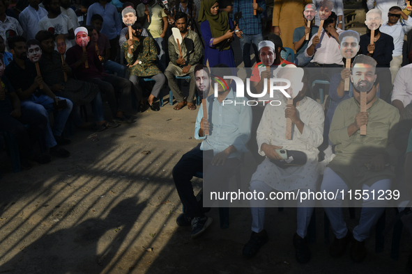 People hold placards with the faces of martyrs at the 'Shohidra Fire Ashche' event, held in memory of those killed in the anti-discriminatio...