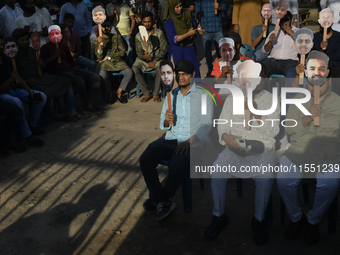 People hold placards with the faces of martyrs at the 'Shohidra Fire Ashche' event, held in memory of those killed in the anti-discriminatio...