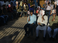 People hold placards with the faces of martyrs at the 'Shohidra Fire Ashche' event, held in memory of those killed in the anti-discriminatio...