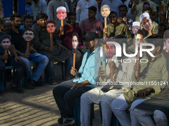 People hold placards with the faces of martyrs at the 'Shohidra Fire Ashche' event, held in memory of those killed in the anti-discriminatio...