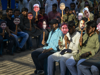 People hold placards with the faces of martyrs at the 'Shohidra Fire Ashche' event, held in memory of those killed in the anti-discriminatio...