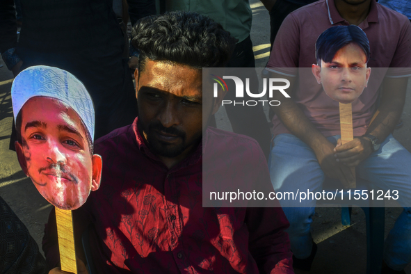 People hold placards with the faces of martyrs at the 'Shohidra Fire Ashche' event, held in memory of those killed in the anti-discriminatio...