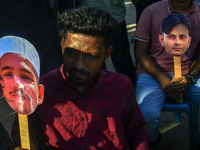 People hold placards with the faces of martyrs at the 'Shohidra Fire Ashche' event, held in memory of those killed in the anti-discriminatio...