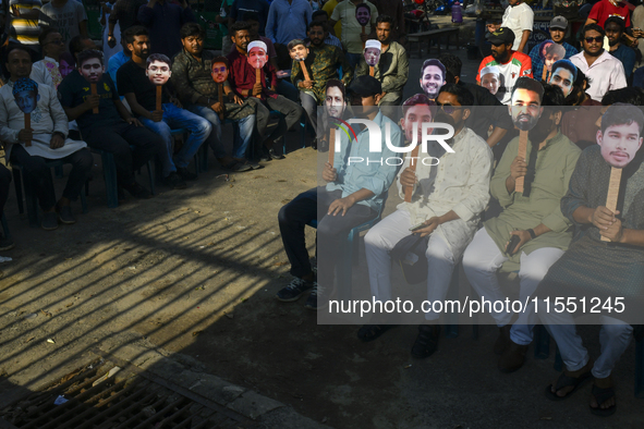 People hold placards with the faces of martyrs at the 'Shohidra Fire Ashche' event, held in memory of those killed in the anti-discriminatio...