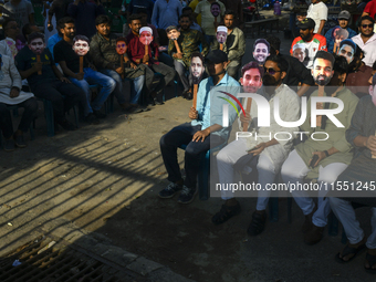 People hold placards with the faces of martyrs at the 'Shohidra Fire Ashche' event, held in memory of those killed in the anti-discriminatio...