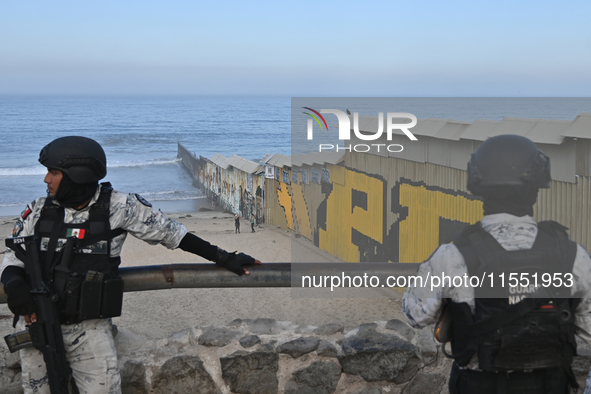 Members of the Mexican National Guard patrol near a new interactive mural of deported veterans at the Playas de Tijuana beach border wall, '...