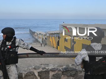 Members of the Mexican National Guard patrol near a new interactive mural of deported veterans at the Playas de Tijuana beach border wall, '...