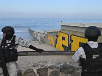 Members of the Mexican National Guard patrol near a new interactive mural of deported veterans at the Playas de Tijuana beach border wall, '...