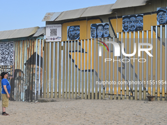 A man looks at a new interactive mural of deported veterans at the Playas de Tijuana beach border wall, ''The Deported Veterans Diaspora,''...