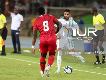 Riyad Karim Mahrez of Algeria competes with Jannick Buyla Sam of Equatorial Guinea during the African Cup of Nations (CAN 2025) qualificatio...