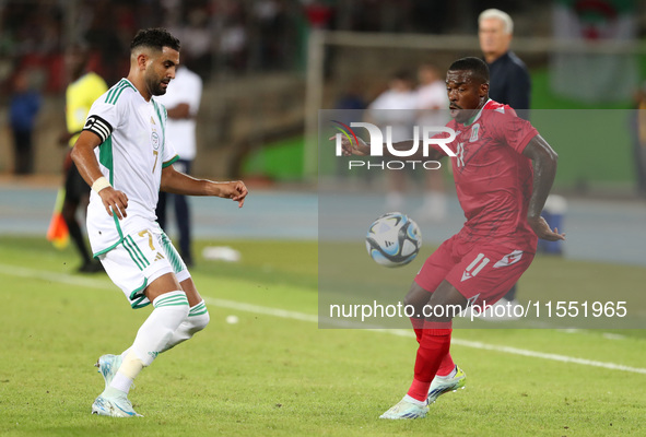 Riyad Karim Mahrez of Algeria competes with Basilio Ndong Owono of Equatorial Guinea during the African Cup of Nations (CAN 2025) qualificat...