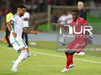 Riyad Karim Mahrez of Algeria competes with Basilio Ndong Owono of Equatorial Guinea during the African Cup of Nations (CAN 2025) qualificat...